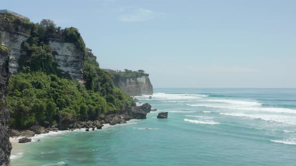 Stunning Tropical Coastline with Steep Rocky Cliffs Near Turquoise Blue Water in Bali Indonesia alt
