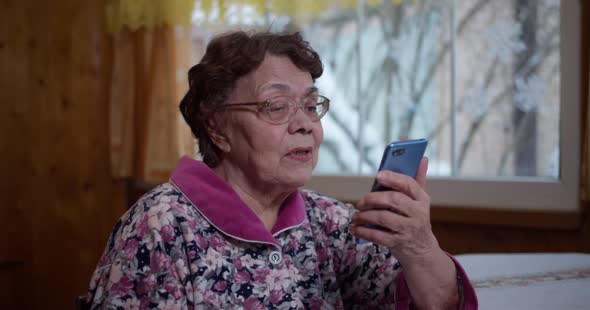 Old Grandmother with a Phone in Her Hands
