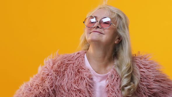 Positive Grandmother Moving on Bright Yellow Background, Style and Fashion alt