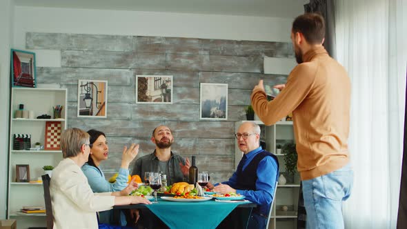 Back View of Young Man Using Smartphone To Take a Group Photo alt