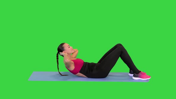 Beautiful Sporty Woman Doing Exercise for Abs on the Floor on a Green Screen Chroma Key alt