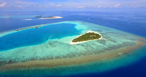 Aerial drone view of scenic tropical island and resort hotel with overwater bungalows in Maldives alt