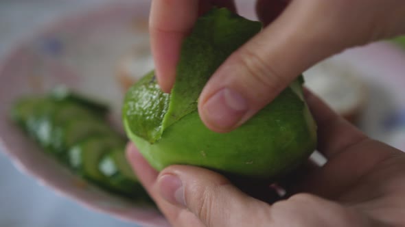 Woman's Hands Taking Out Pulp Of Avocado