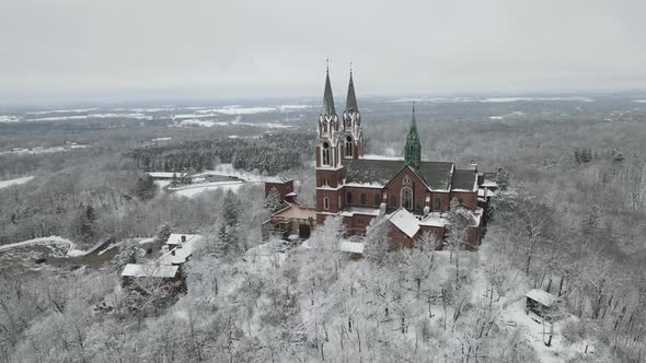 Panoramic up view of religious complex in winter. Surrounding land and trees covered with snow.