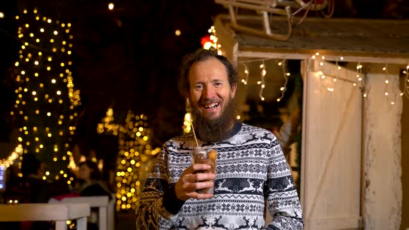 Happy man holding traditional fritula at Christmas market. Zagreb, Croatia alt