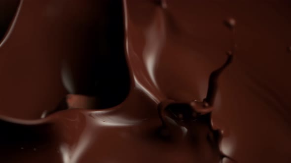 Super Slow Motion Shot of Raw Chocolate Chunks Falling Into Melted Chocolate at 1000Fps. alt