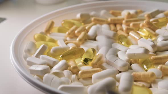 Different Pills with Capsules and Tablets Falling on White Plate White Table Concept of Medical