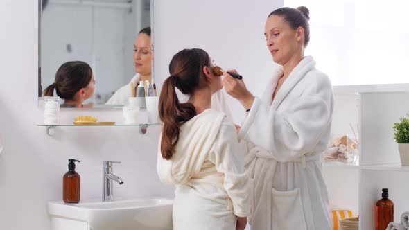 Mother and Daughter Applying Make Up in Bathroom