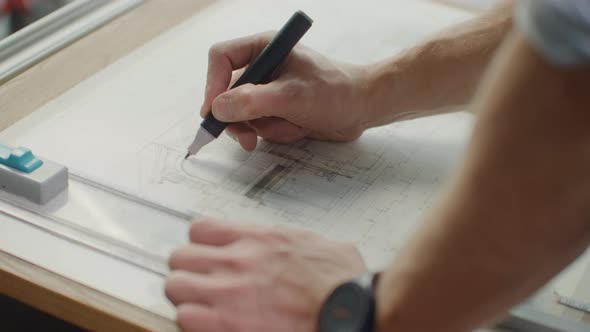 Close Up of Architect Hands Making House Blueprint in the Office Near Window alt