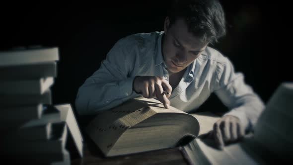 Man Working Late and Searching into Old Big Books