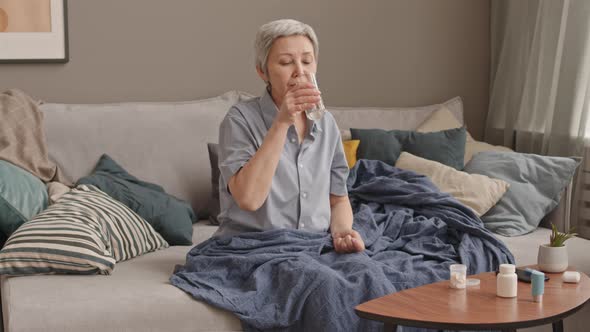Senior Woman Taking Medicine before Napping alt