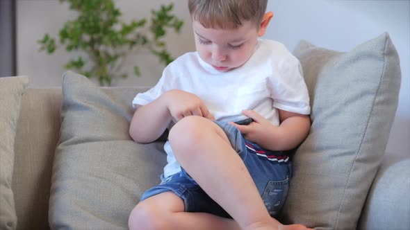 Child Tech Addiction Concept Play Game at Home. Little Boy Preschool Child Using a Digital Tablet alt