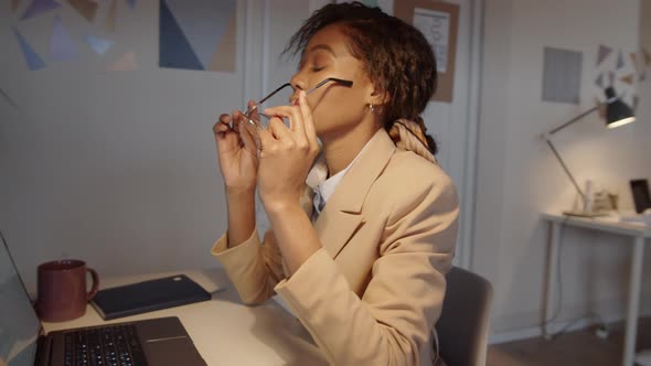 Overworked Afro-American Businesswoman Typing on Laptop in Office alt