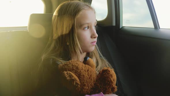 Pretty Girl with Teddy Bear Looking Out Window During Summer Car Trip Lifestyle alt
