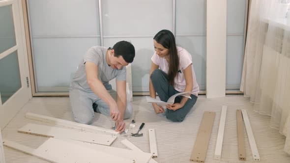 Wife Helping Husband To Assemle Furniture alt