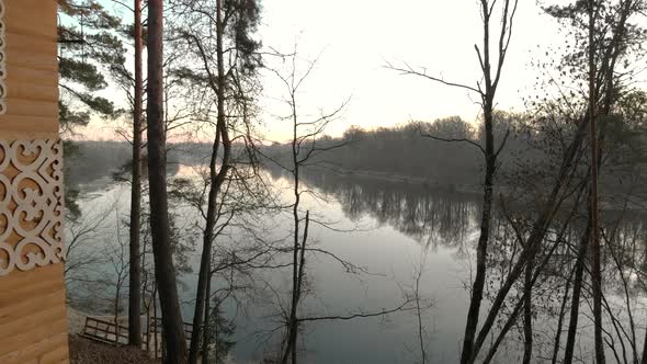 Wooden Cottage of a Small Lake in the Autumn Evening, Approaching Sunset