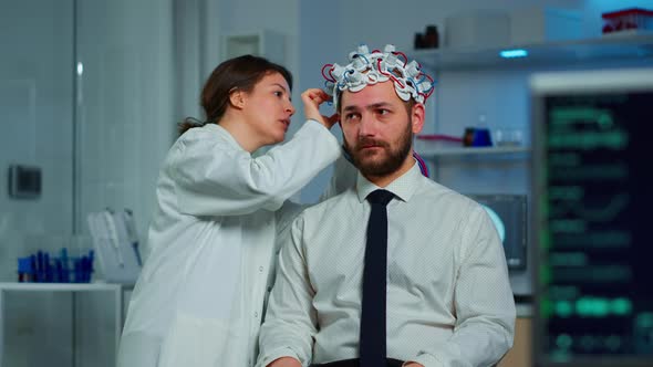 Patient with Brainwave Scanning Headset Sitting in Brain Study Lab alt