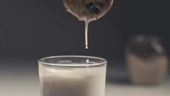 Dipping A Chocolate Chip Cookie In Milk. Slow Motion