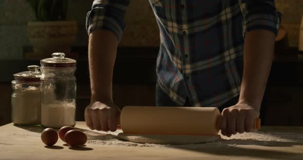 Male Hands Roll Out Pizza Dough with a Rolling Pin