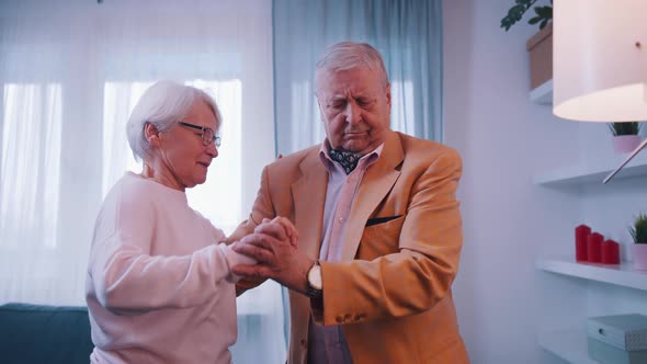 Happy Old Married Couple Dancing in Hotel Room alt