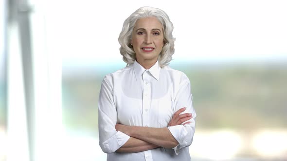 Portrait of Senior Businesswoman on Blurred Background. alt