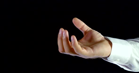 Close-up of Male Hand in White Shirt Unclenches Fist and Spread Fingers on Black Isolated Background alt