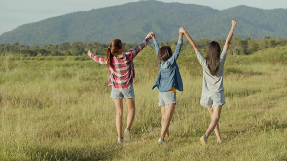 Group of a young Asian woman holding hands walking having fun together a summer traveling.