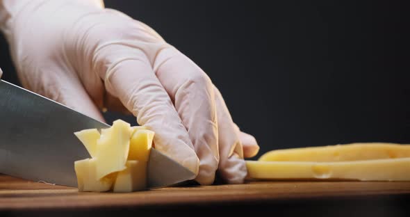 Person Cuts Delicious Cheese Into Cubes with Large Knife alt