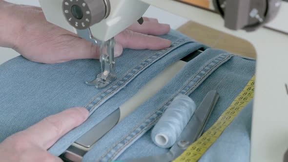 Seamstress is Working Sewing Clothes in Sewing Machine Hands Closeup alt