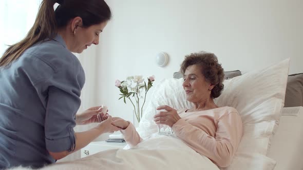 Nurse Administering Medications to Female Senior Patient