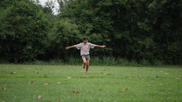 Slow motion, Happy little girl running and smiling in the park alt