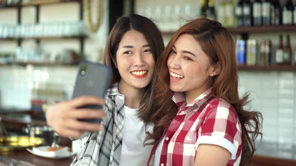 two cheerful woman taking selfie on a smartphone
