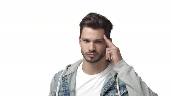 Slow Motion Sassy and Confident Attractive Man with Beard Saluting you Touching Temple with Fingers alt