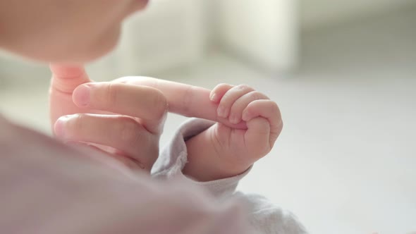 Newborn Baby Hand Holding Mother Mom Touching Baby Tiny Hand to Make Him Feeling Her Love Warm and alt