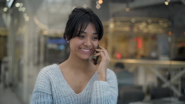 Middle Shot of Asian Female Standing Laughing Talking on Phone