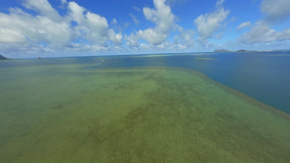 Coral Reef of the Pacific, Blue Green Sparkling Water Below and Fluffy Summer Clouds Above alt