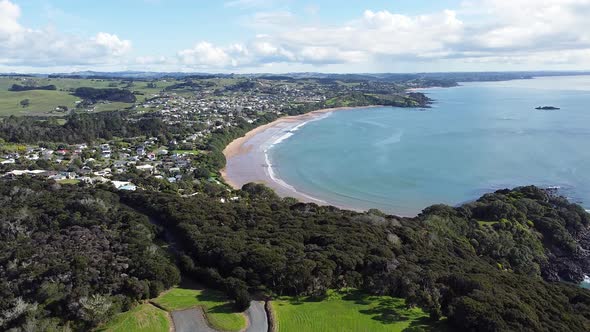 Rising aerial drone of Coopers Beach township and stunning curved bay Doubtless Bay, Northland in Ne alt