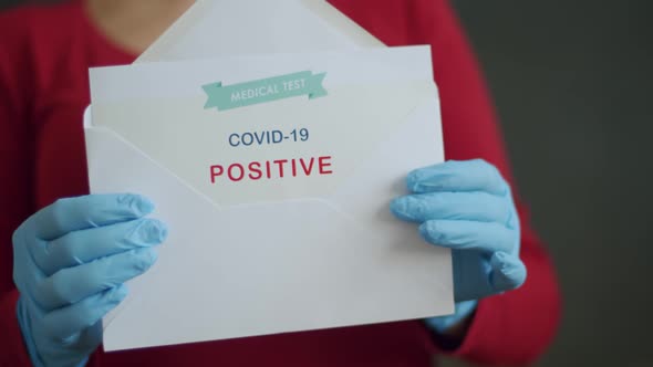 Woman Holding Positive Antigen Detection Test for Covid-19