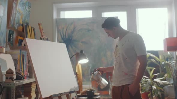 Artist Drinking Coffee and Drawing Picture in Studio alt