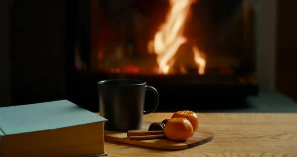 Cozy Autumn or Winter Mood with Fireplace Hot Tea Book and Tangerines