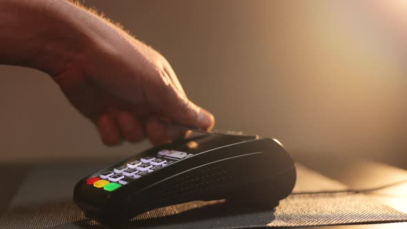 Close up Hands of Man Making Payment With Credit Card Machine Terminal While Swiping Debit Card