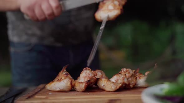 Chief Removes Grilled Chicken Wings From the Skewers