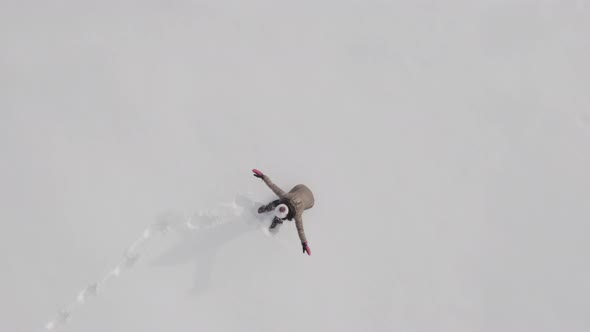 Woman making a snow angel alt
