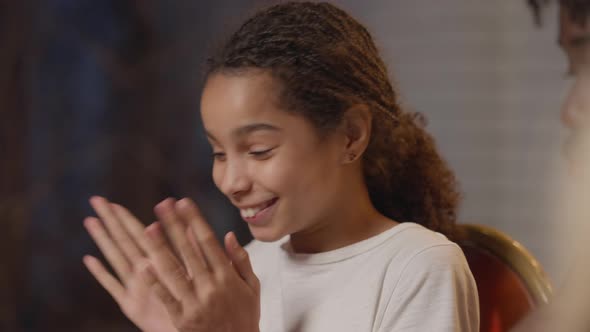 Closeup of Cheerful Teenage African American Girl Clapping Admiring Picnic Table Sitting with Family alt