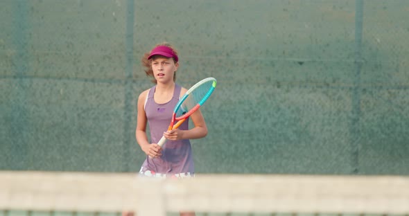 Athletic Girl Playing Tennis on Court. Active Teenager Is Hitting Ball By Racket alt