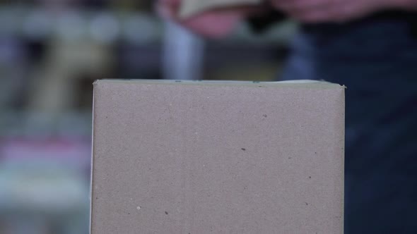 Logistician Puts a Label on the Packaging alt