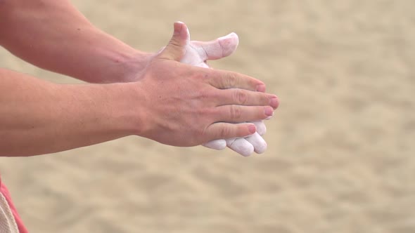 Young man prepares to swing on the Santa Monica traveling rings. alt