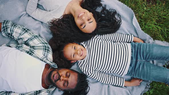 Top View of Happy African Family Resting and Having Fun on Picnic in City Park Enjoying and Lying on alt