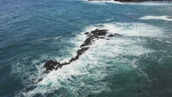 Aerial top view of rocks in the sea - Aerial video of majestic waves splashin