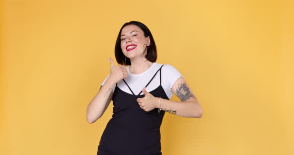 Positive young stylish woman looking approvingly at camera show thumb-up  alt